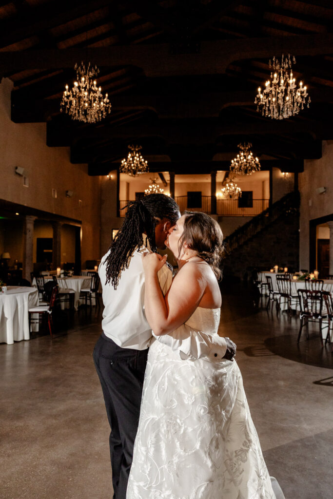 The couple enjoys their first dance beneath chandeliers inside Ma Maison