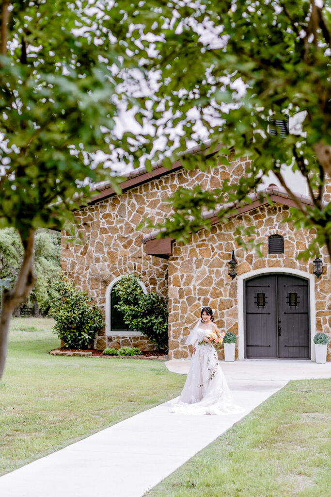bride walking in front of Ma Maison wedding venue in Dripping Springs, Texas