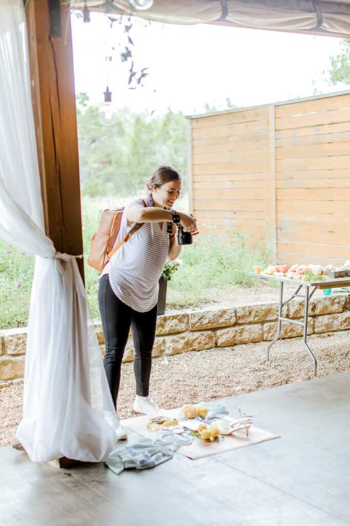 photographer in a t-shirt and pants taking photos at Ma Maison wedding venue in Dripping Springs