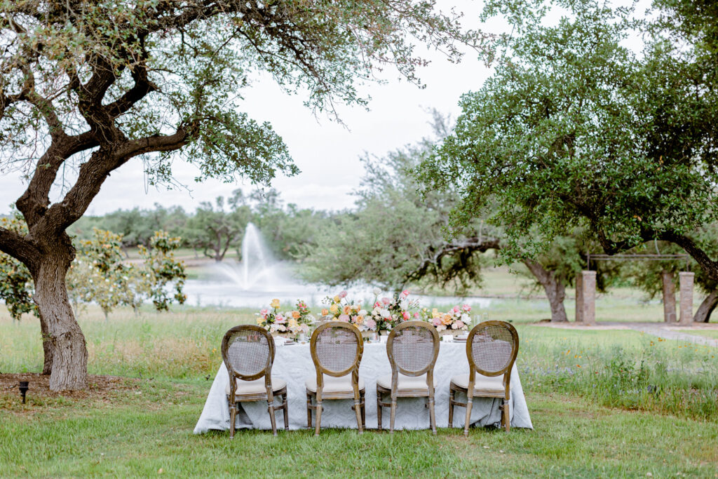 reception table design in front of fountain at Ma Maison wedding venue in Dripping Springs, Texas