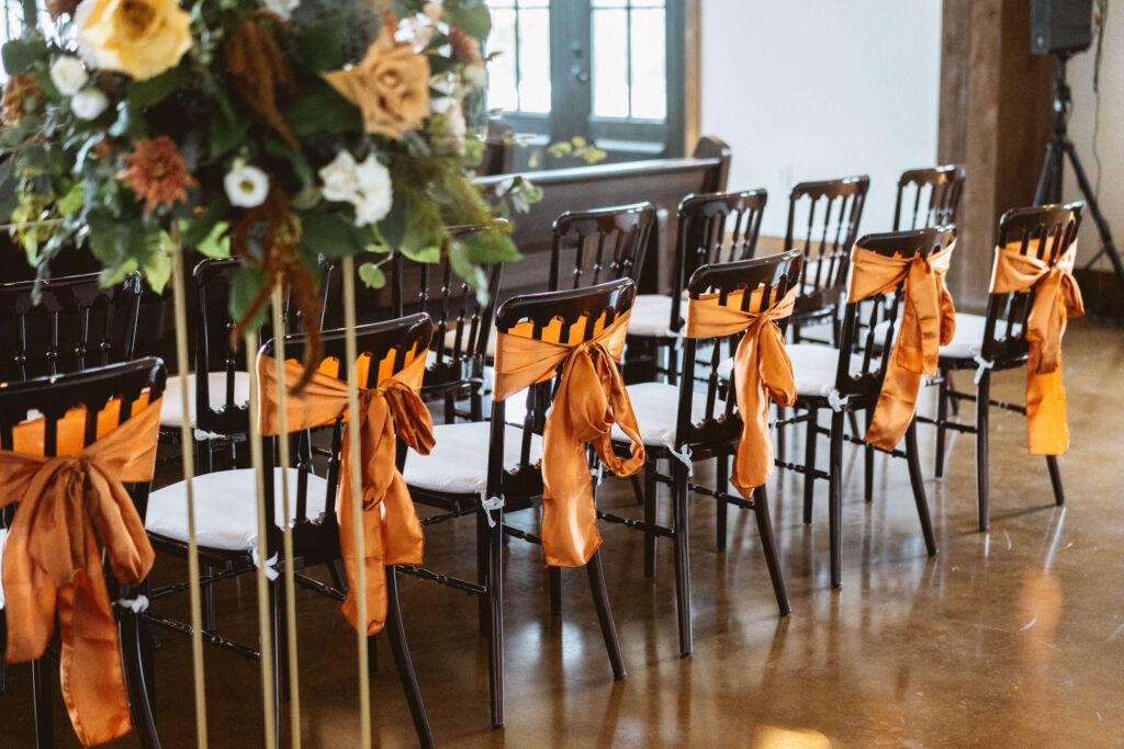 chairs with orange bows at spring wedding