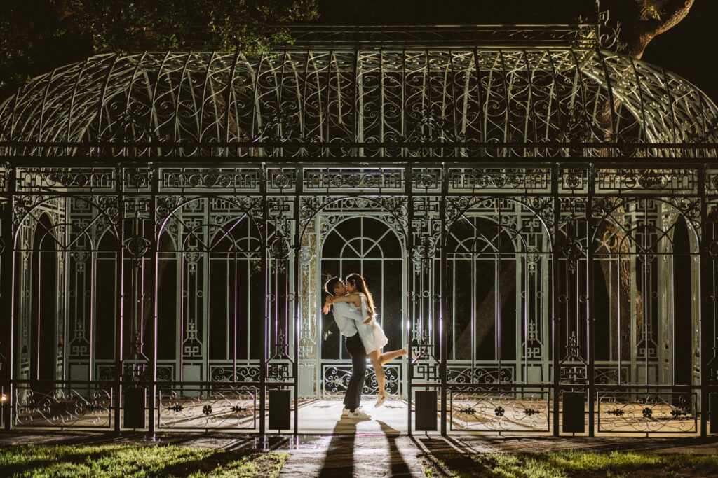 bride and groom kissing underneath garden area at Ma Maison wedding venue in Dripping Springs, Texas