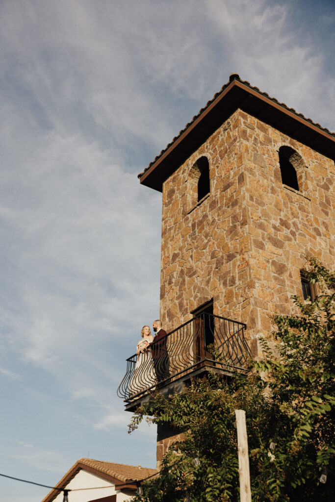 Bride and groom on a stone Bell Tower balcony at a non barn wedding venue in Austin