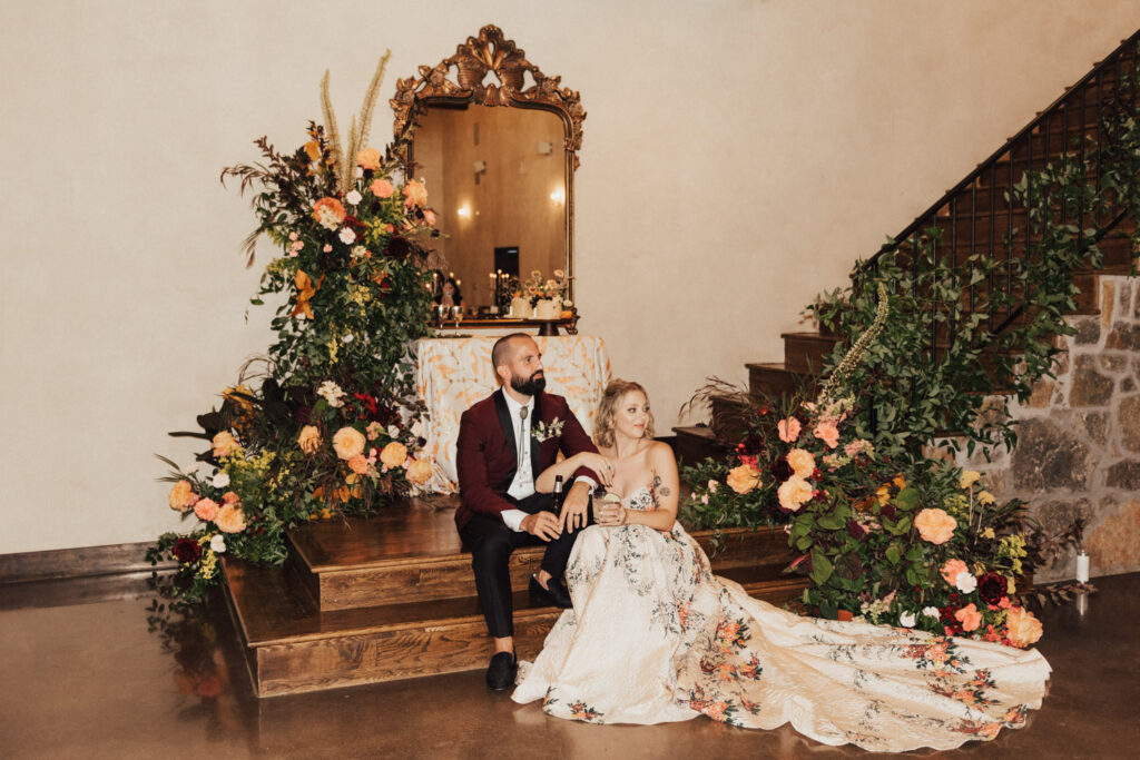 Couple sitting inside elegant non barn wedding venue in Austin with floral decor