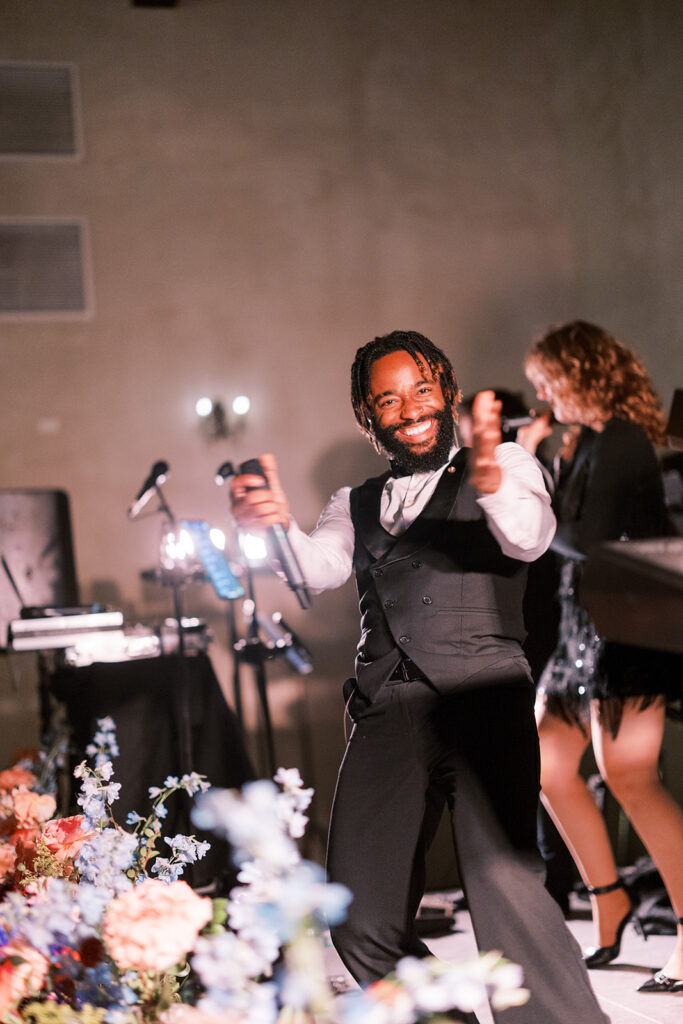 Wedding guest dancing in front of a live reception band.