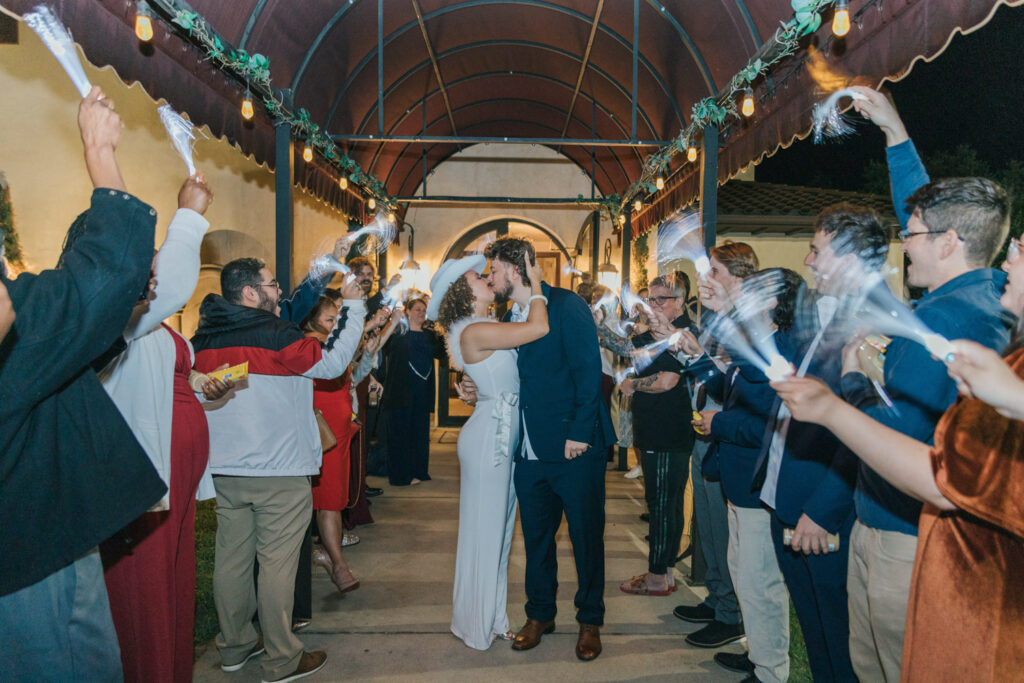 Couple kissing during wedding exit on a rainy wedding day