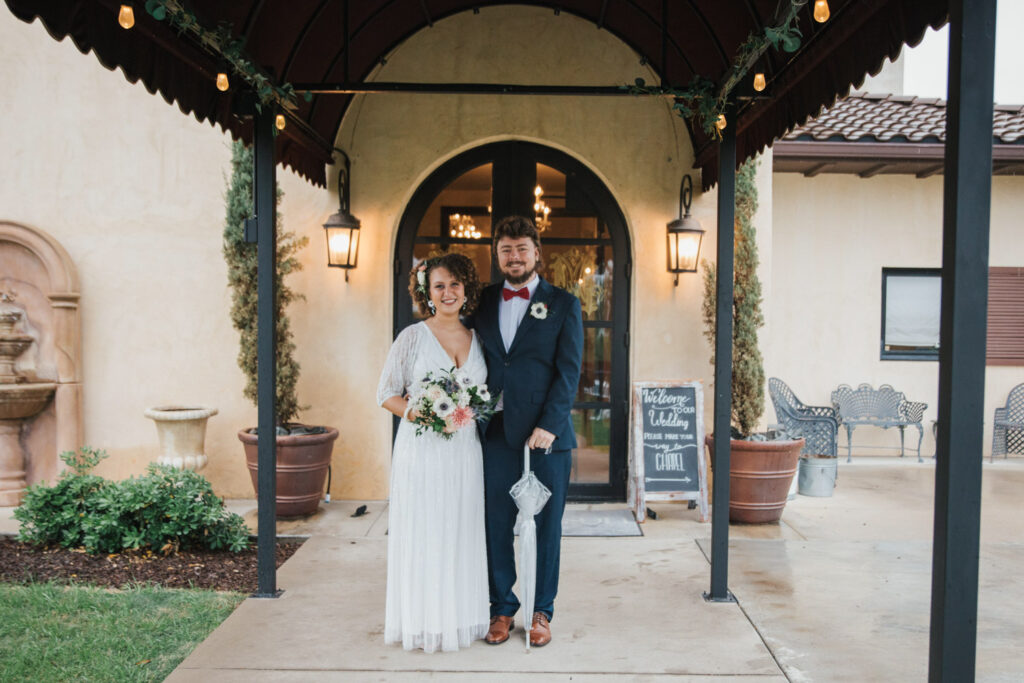 Newlyweds stand at venue entrance