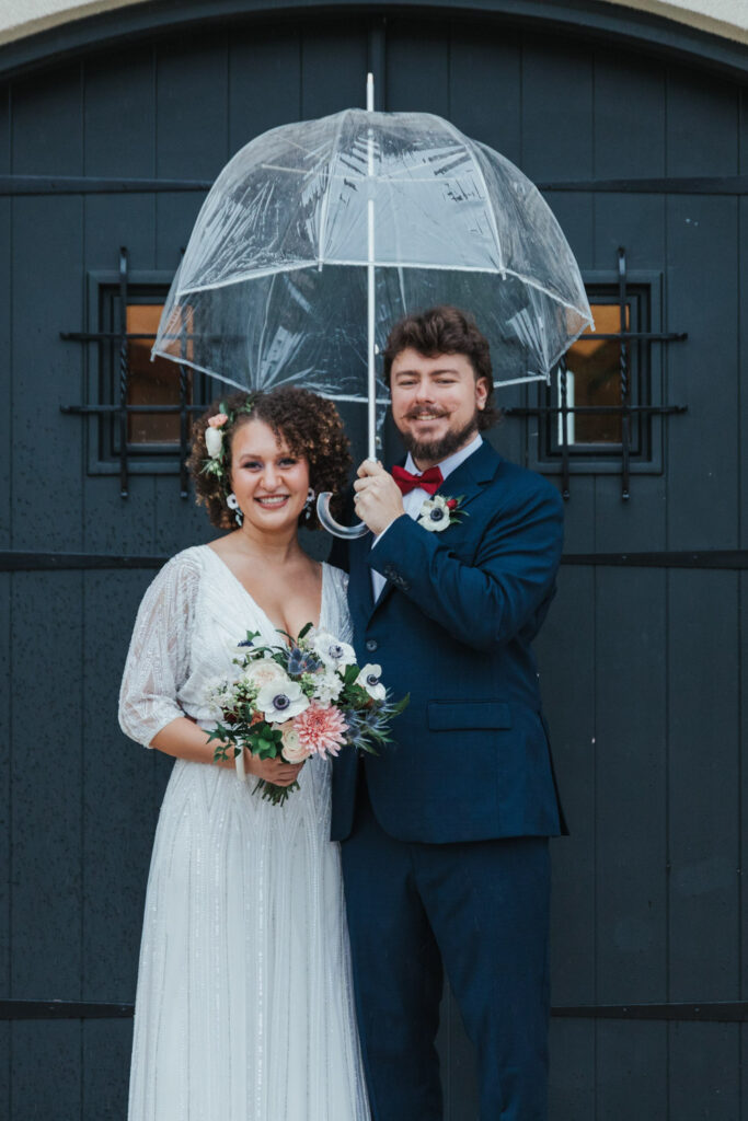 Couple with umbrella in front of doors