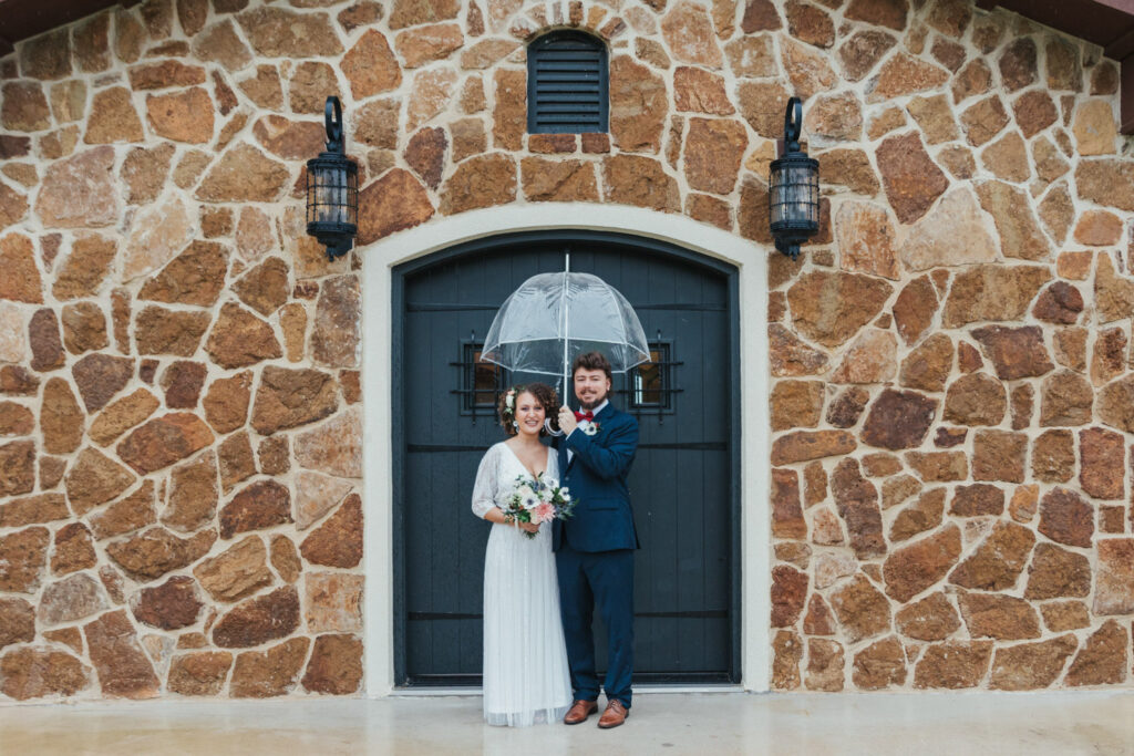 Bride and groom by stone wall