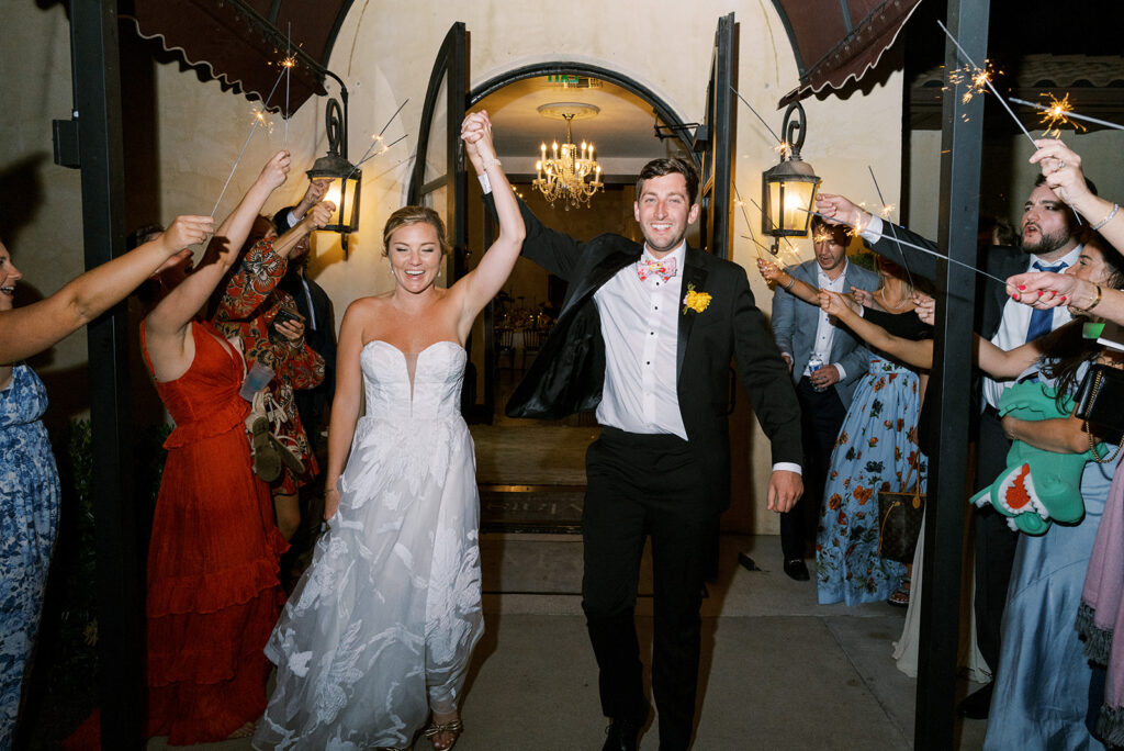 Bride and groom celebrating during their wedding sparkler exit.