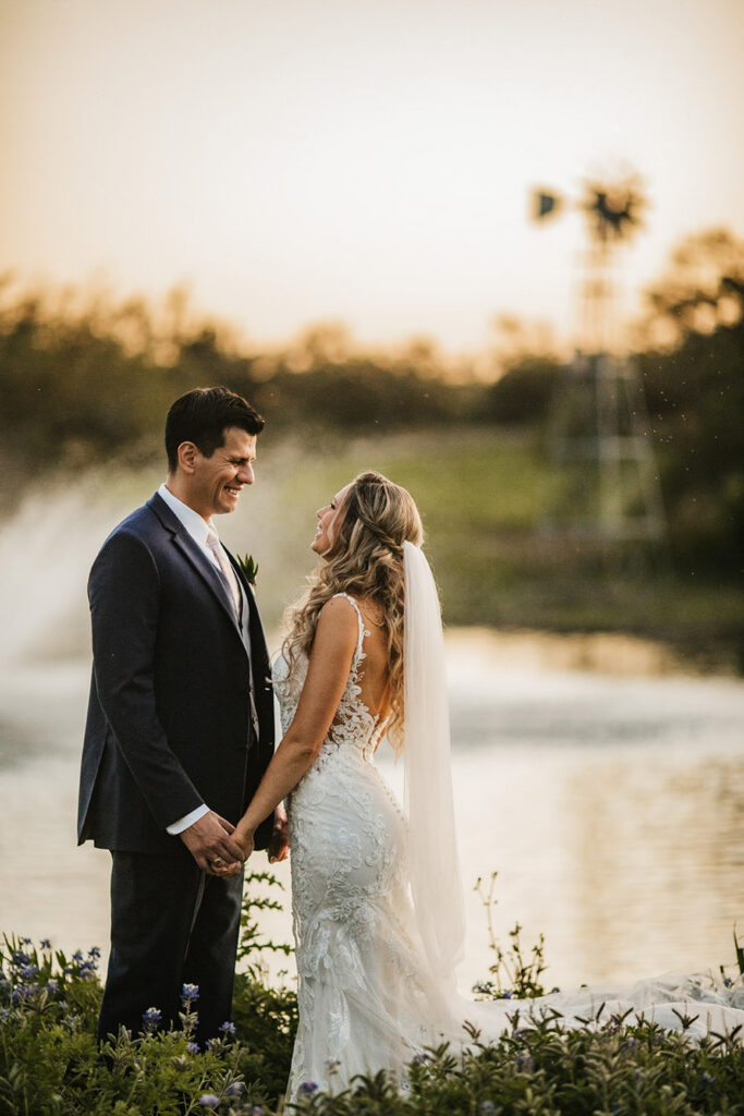 A bride and groom share a sunset moment by the pond capturing Sustainable Wedding Venues in Austin
