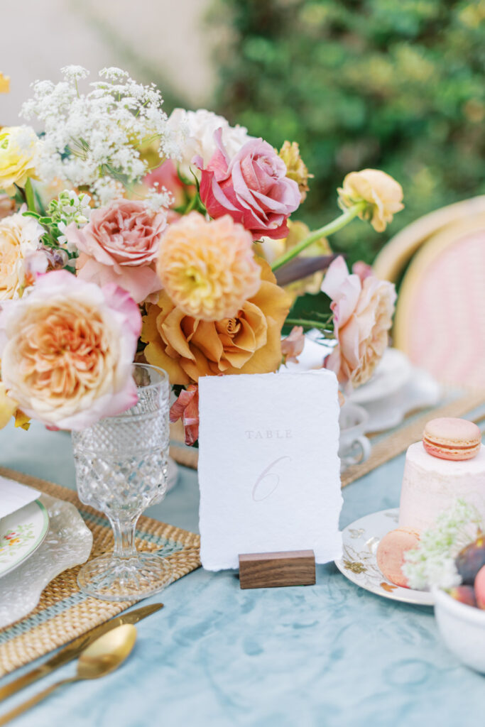 Wedding table centerpiece with pastel roses and table number card