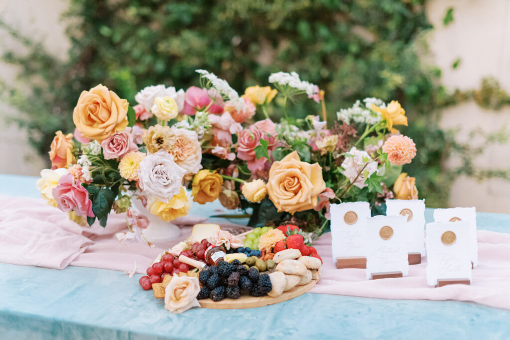 Wedding charcuterie display with floral centerpiece and place cards