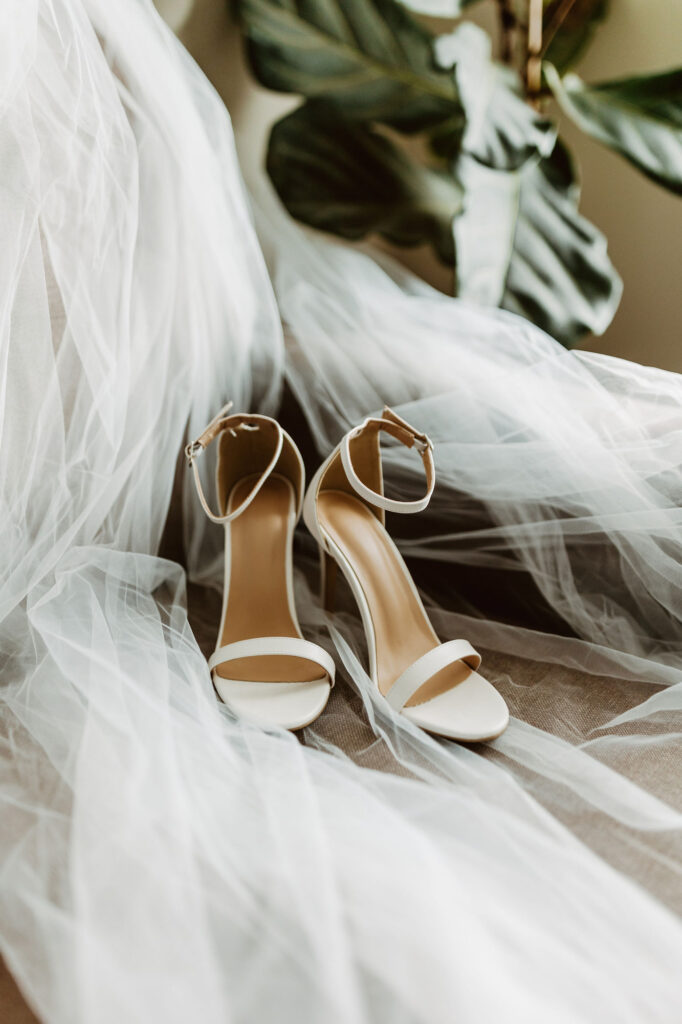 white high heels sitting on veil in bridal suite