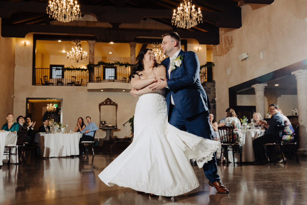 Bride and groom share their first dance under sparkling chandeliers 