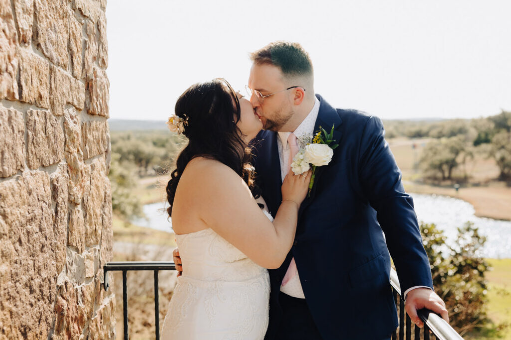 The bride and groom kiss with natural light and Tuscan architecture setting a dreamy backdrop