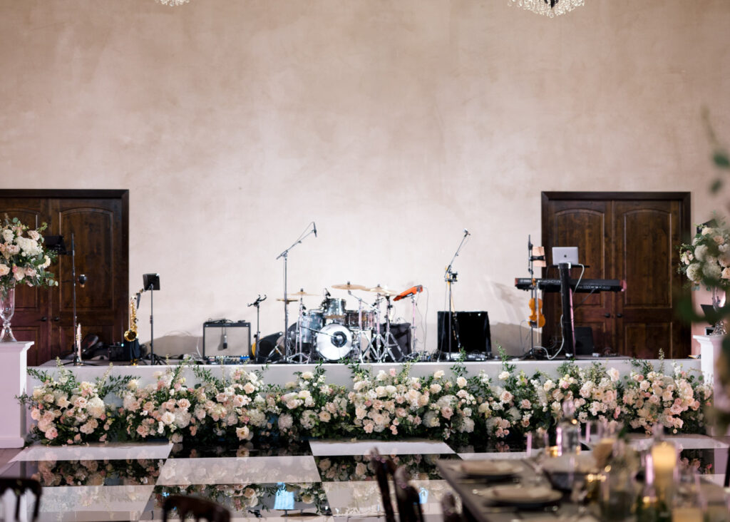 Close-up view of a floral-lined stage and black-and-white dance floor