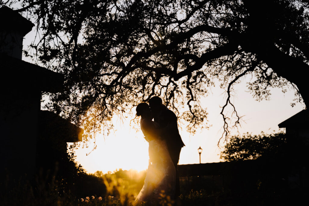 Silhouette of couple kissing at sunset—romantic and unique wedding moment