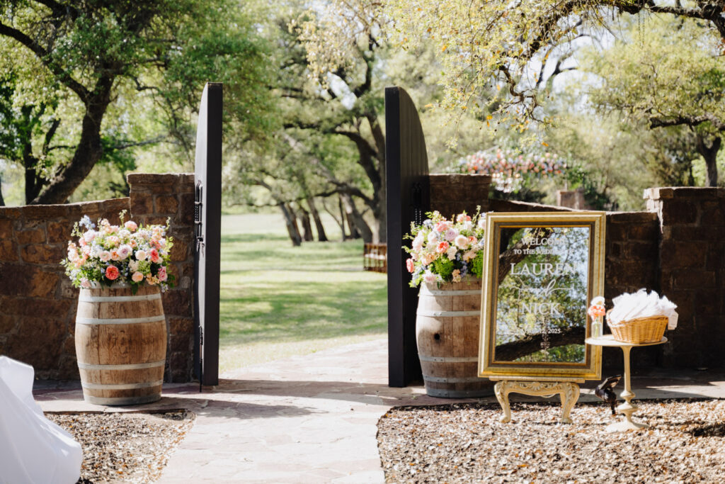 Creative outdoor ceremony entrance with florals and mirrored welcome sign