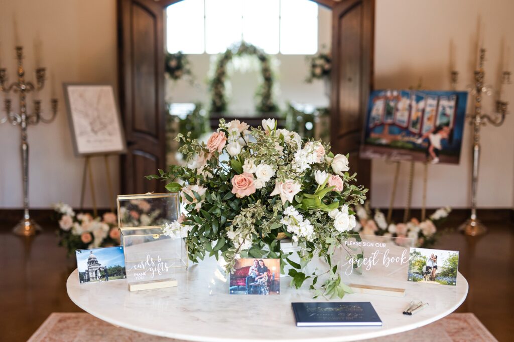 Wedding guestbook table with floral centerpiece and framed photos