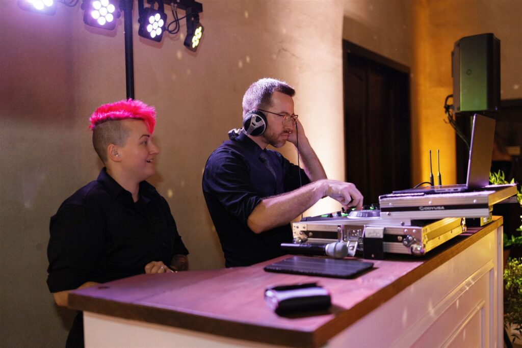 Wedding DJ in Austin mixing tracks while guests enjoy the reception party.