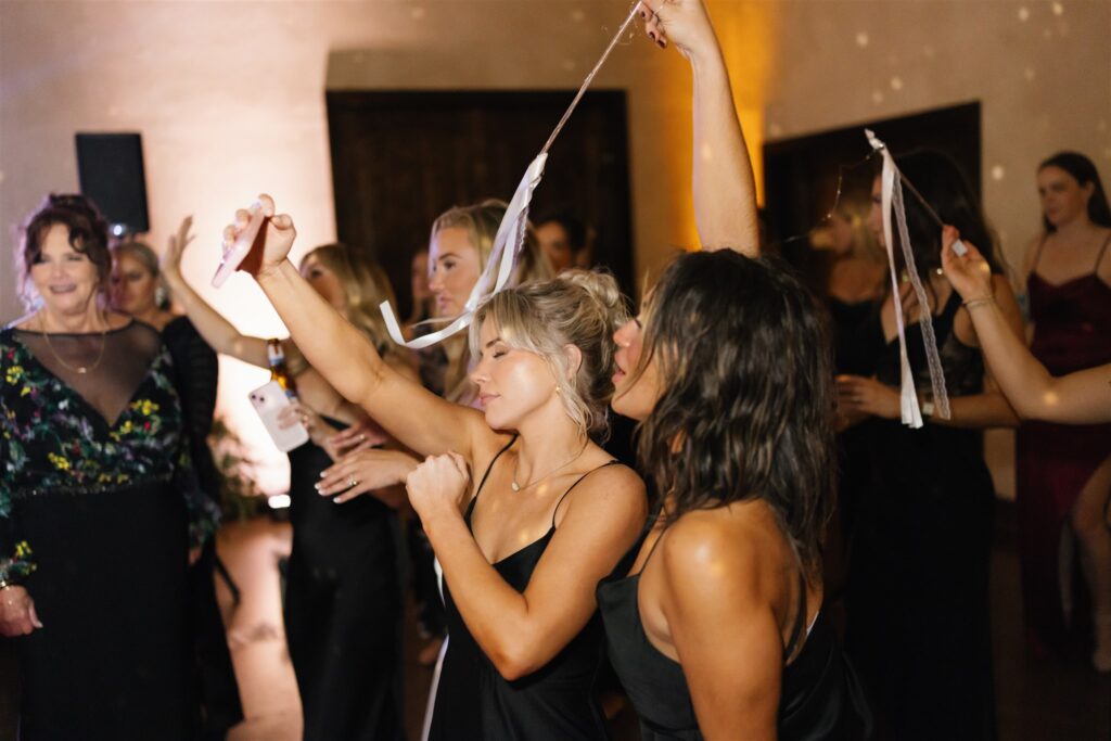 Bridesmaids dancing with ribbon wands during a lively set by a Wedding DJ in Austin.