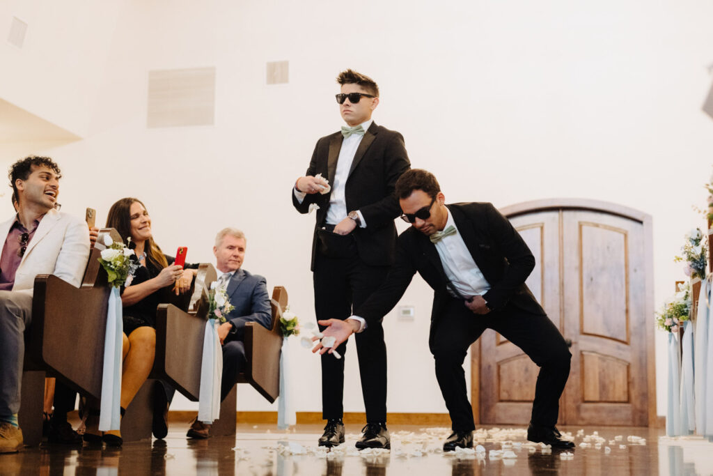 Wedding guest happily throwing flowers at the wedding aisle