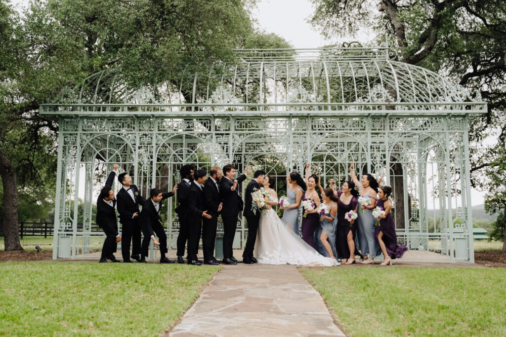 Married couples kiss in front of Green Cathedral with their wedding party