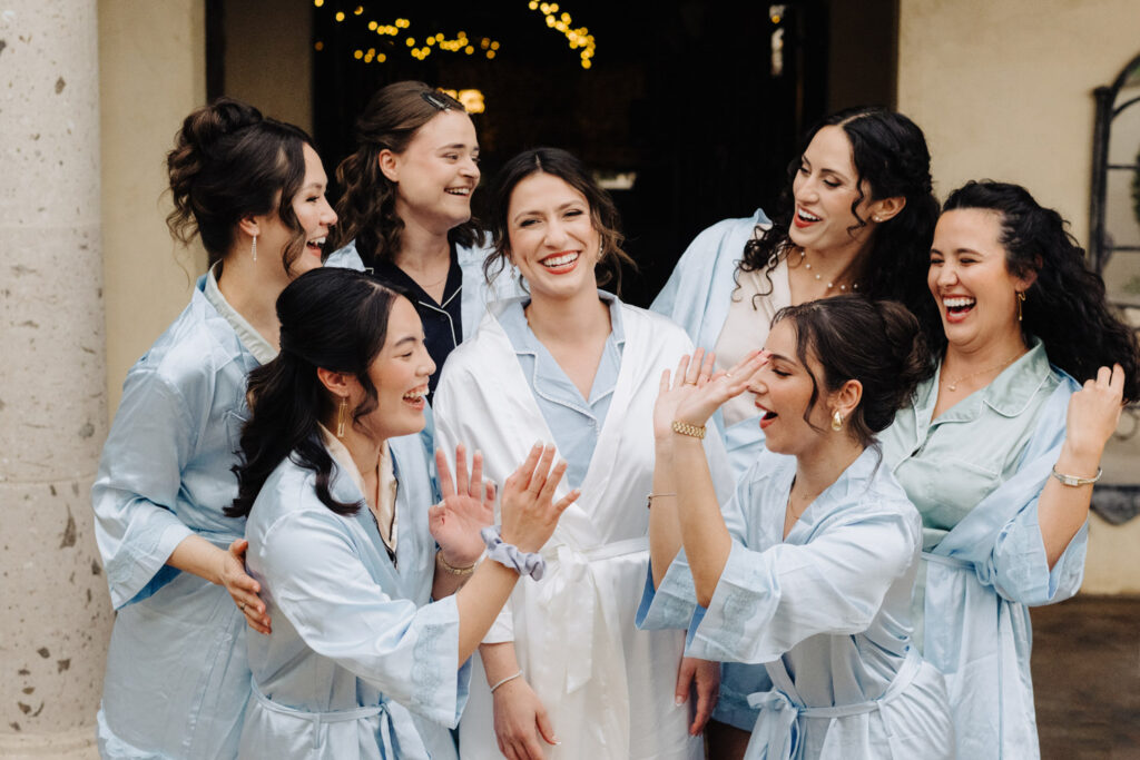 Bridesmaids having fun with the bride while preparing