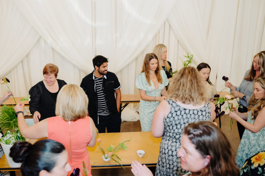Wedding planner in Austin guiding guests in a flower workshop
