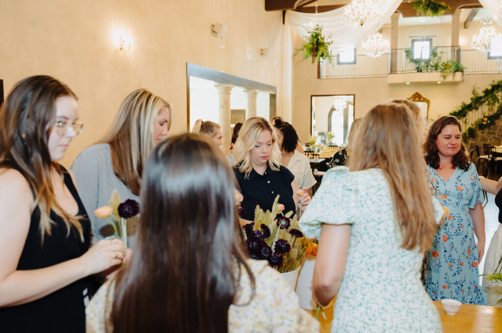 Group arranging flowers during an event with a wedding planner