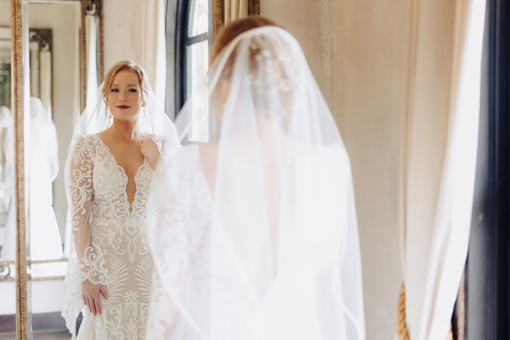 Bride admires herself in the mirror before walking down the aisle