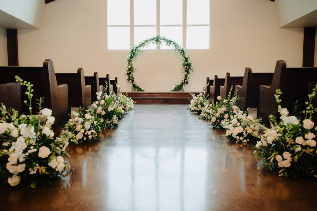 Floral-lined aisle and circular arch in chapel set