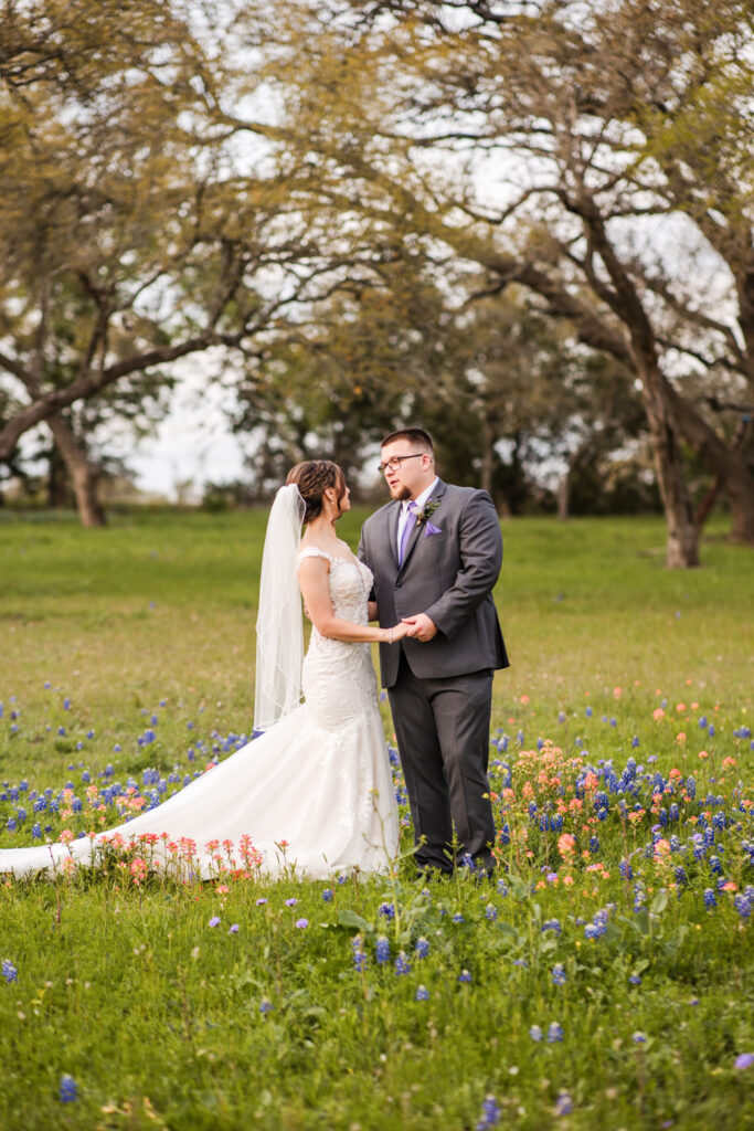 Couple standing together in a wildflower field during springtime at Ma Maison