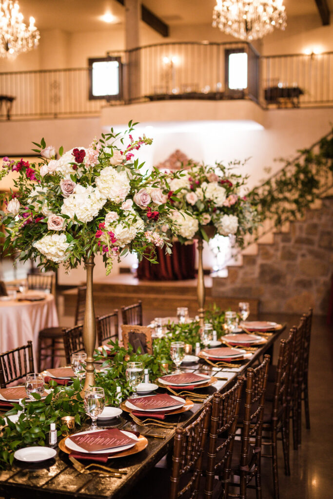 Elegant indoor reception table with tall floral centerpieces at Ma Maison