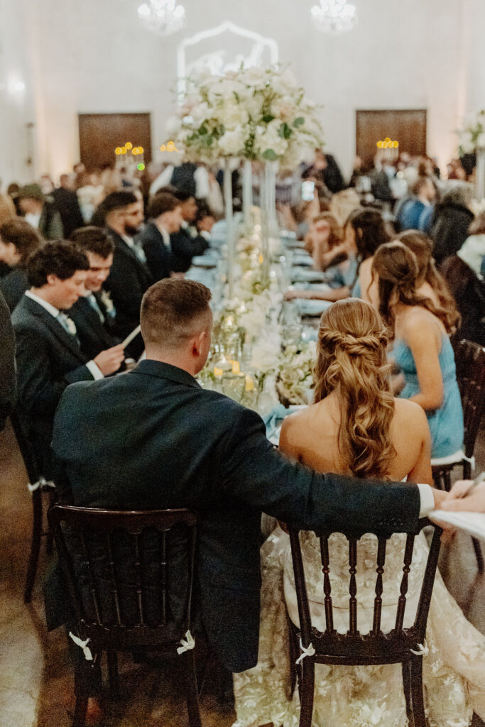 A beautifully styled wedding reception at Ma Maison, featuring long banquet tables, lush floral arrangements, and candlelit elegance.