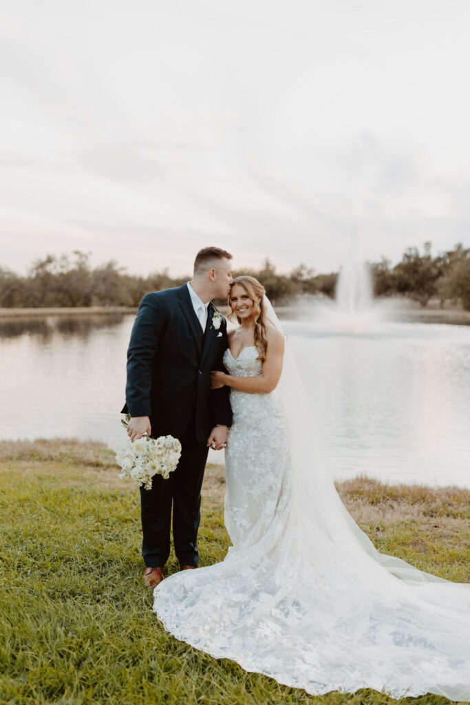 Romantic moment of a wedding couple by the serene lake at Ma Maison, the most popular wedding destination in Austin