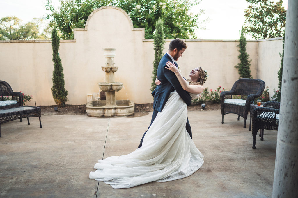 bride and groom share a dip pose at outdoor Texas wedding venue