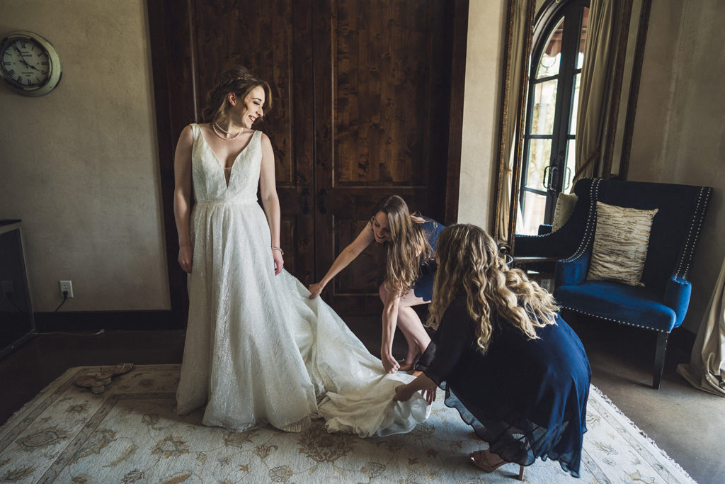 bride getting her dress on at Texas wedding venue