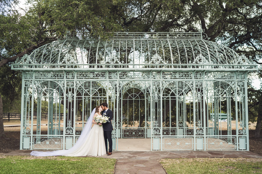 bride and groom posing in front of iron trellis at one of the best places to get married in Texas