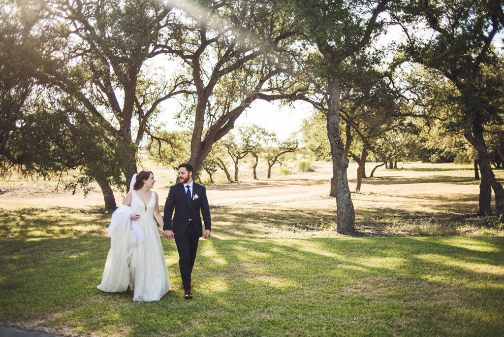 bride and groom walking on their wedding day at outdoor Texas wedding venue