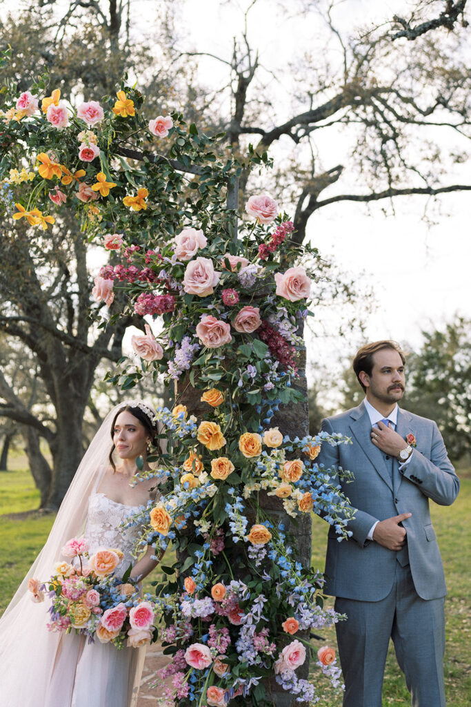 Floral arch with pink roses, yellow tulips, and delphiniums