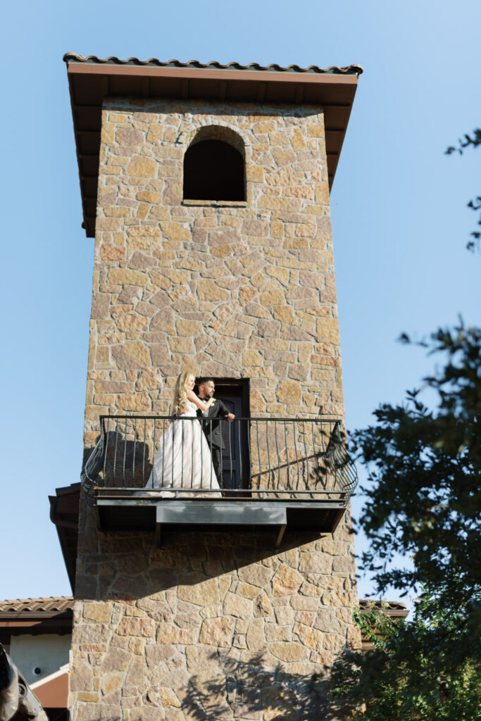 Bride and groom on stone tower balcony