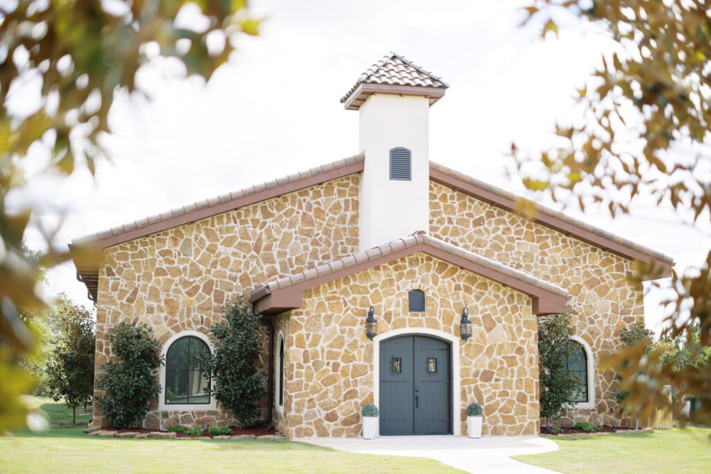Stone chapel exterior surrounded by greenery for intimate wedding venues near Austin