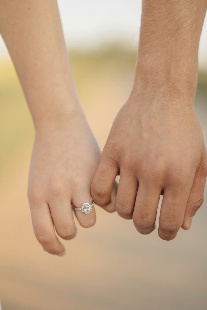 Couple holding hands, showing off lab-grown diamond engagement ring