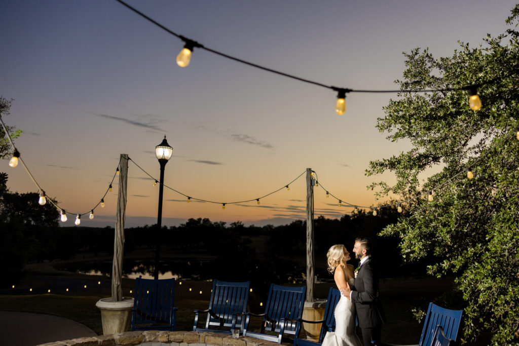 Couple enjoying golden hour under string lights at a romantic Dripping Springs location