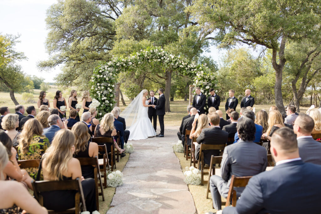 Outdoor ceremony under floral arch at one of the most romantic spots in Dripping Springs
