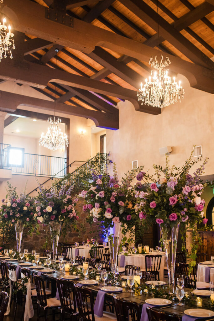Tall floral centerpieces with chandeliers at a unique wedding venue