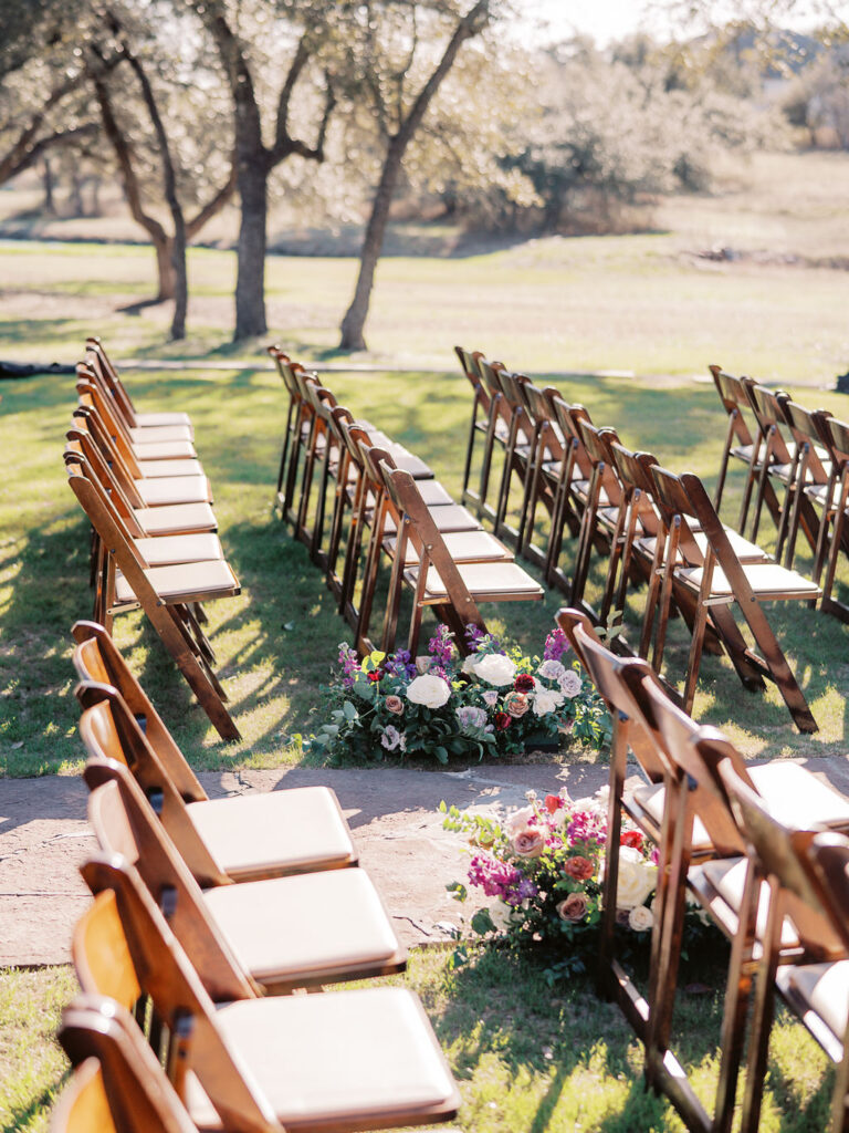 Outdoor ceremony chairs with floral aisle decor for wedding
