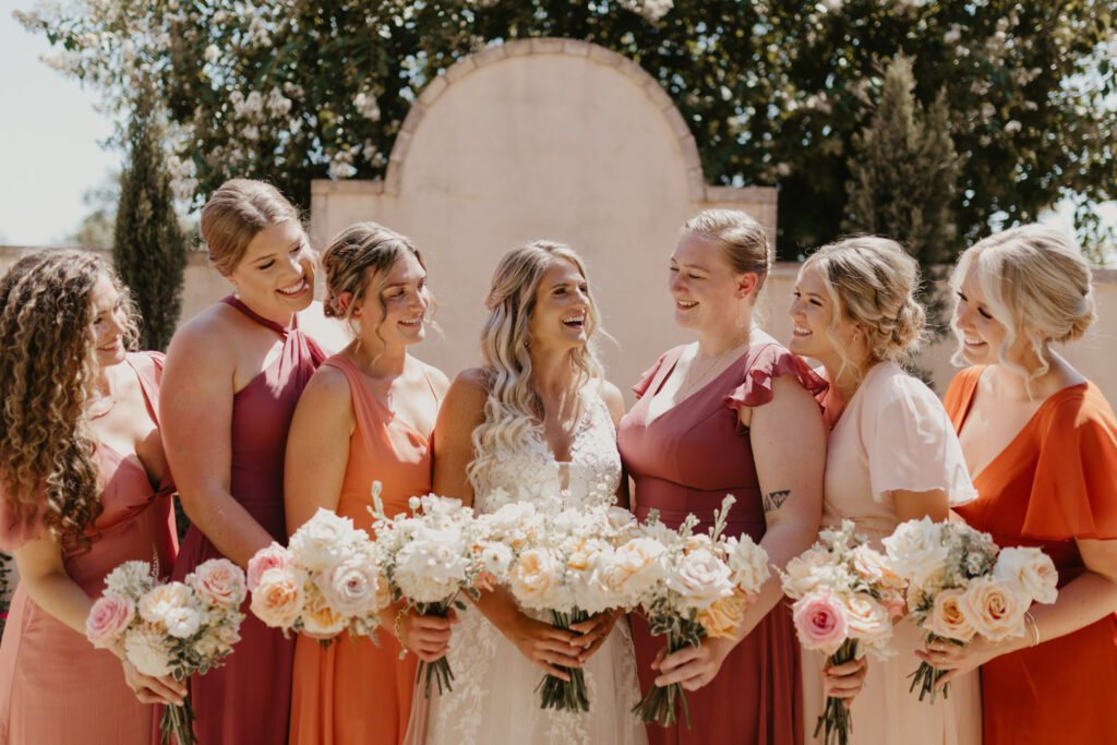 Bride with bridesmaids holding bouquets that may include some of the worst wedding flowers for heat